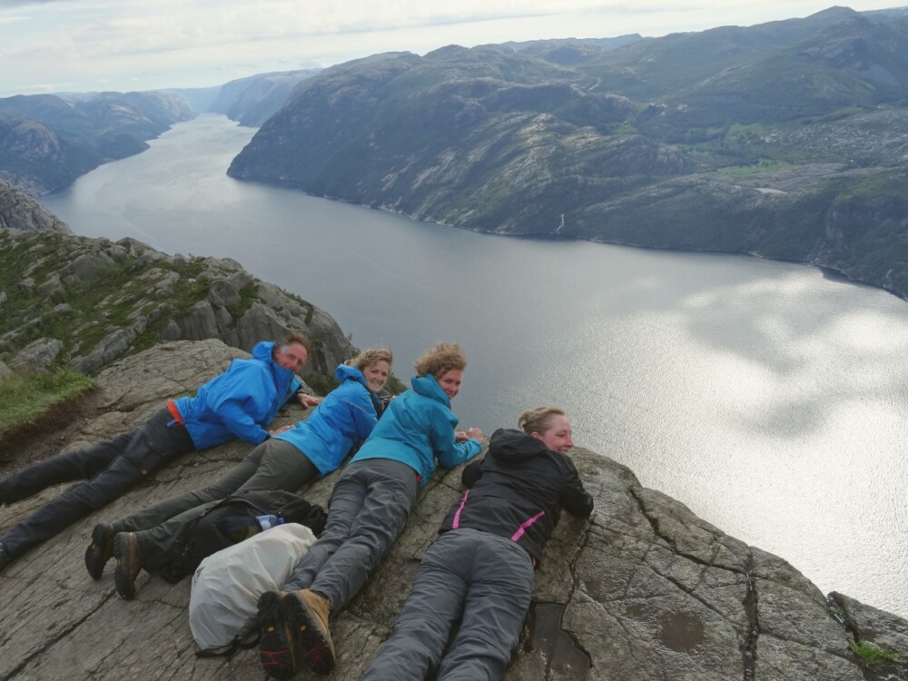 Liggend op de rand van rots Preikestolen.